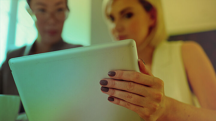 Zdjęcie dwóch osób wpatrujących się w ekran laptopa.
